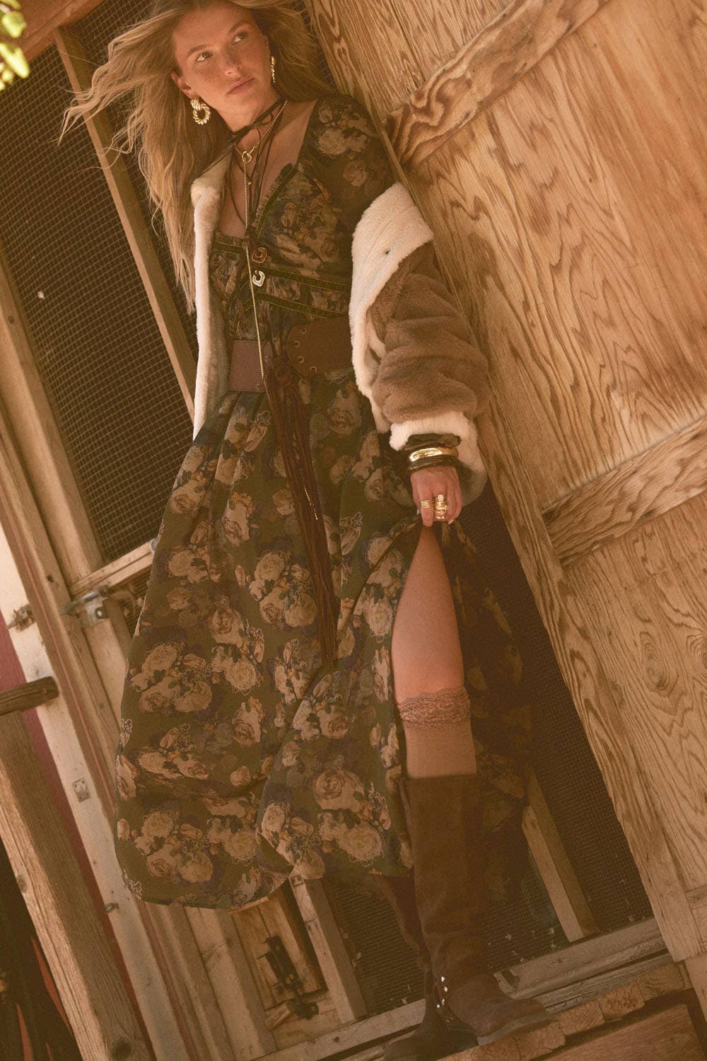Woman wearing a dark floral velvet-trim maxi dress with long bubble sleeves and V-neckline