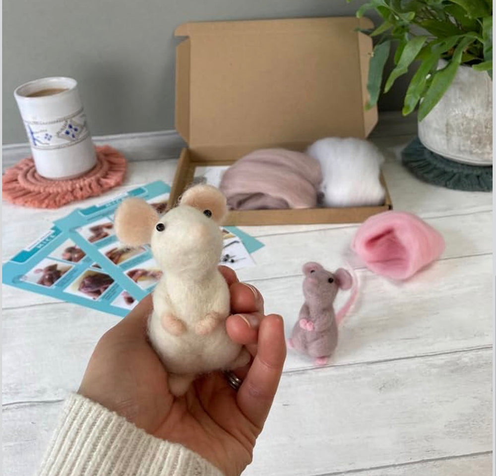 Hand holding a finished needle-felted mouse next to the Bergin & Bath kit